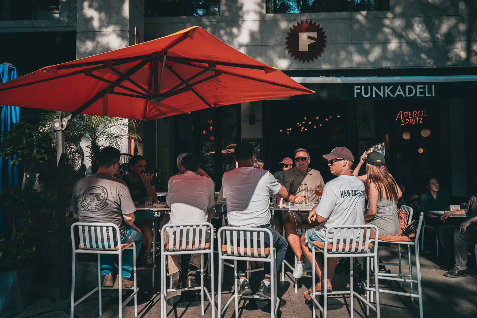 Gezelschap aan hoge tafels op een zonnig terras